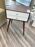 Full view of wood side table with two white drawers and tapered legs, showing overall design and condition.