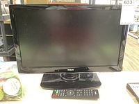 Front view of the 18-inch RCA LED TV powered off with remote on stand.