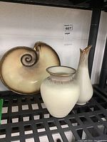 Photo showing the pottery vase, tall jar, and nautilus shell tray together on a black shelf, showcasing color gradients and textures of items.