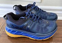 Side view left shoe showing blue and grey upper, blue midsole, and yellow outsole with lugged tread.