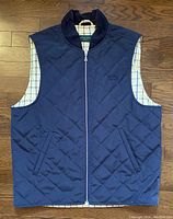Full front view of navy blue quilted side showing zip closure and pockets.
