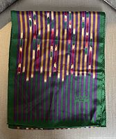 Full view of folded scarf showing multi-color vertical stripes, brush stroke accents, green border, and Lanvin Paris logo.