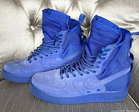Side angle of Nike SF Air Force 1 High royal blue high-top sneakers showing the suede and nylon construction and rubber sole
