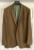 Front view of vintage brown men's blazer on hanger showing single-button closure, notch lapels, and three exterior pockets.