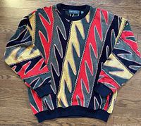 Front view of vintage Tundra Canada sweater showing multicolor 3D flame design and ribbed cuffs, collar, and waistband.