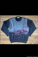 Full view of vintage men's wool blend crew neck sweater with abstract pattern laid flat on wooden floor.