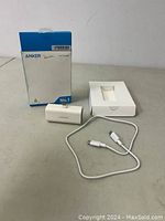 White Anker Nano power bank with original box, white charging cable and inner tray on a gray surface.