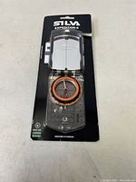 Front view of the Silva Expedition S compass in sealed packaging showing the baseplate, orange bezel with degree markings, and clear lid with sighting lines.