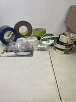 Full lot with multiple rolls of tape in blue, brown, white and clear plus a pair of new safety glasses in blister packaging.