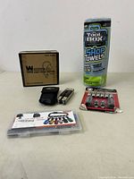 Overview of all items in the lot: boxed foot pedal switch, multi-tool, quick connect fittings, 1/4" Hex Shank Holder set in plastic case, and roll of shop towels.