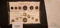 Photo showing the 1968 and 1969 Canadian coin sets in white holder cards. The 1969 set has one missing dime slot.
