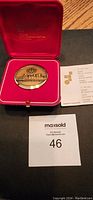 Front view of the Montreal 1976 Olympic medallion in red lined box with certificate and label.