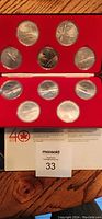 Photo of Air Canada 40th anniversary coin set from 1937-1977, showing 10 silver-colored commemorative coins displayed in a red case with original certificate.
