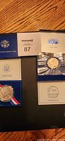 Photo showing three uncirculated Liberty coin sets including half dollar and silver dollar coins in original presentation packaging with certificates.
