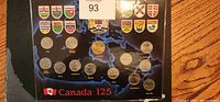 Canada 125 quarters coin set shown with coins arranged on a map background with provincial shields.