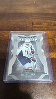Close-up of Alex Ovechkin hockey trading card in plastic protective case on wooden surface.
