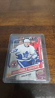 Close-up photo of Auston Matthews rookie hockey card in clear plastic protective case showing player in action and card details.