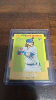 Photo of Bo Bichette Rookie baseball card in protective plastic sleeve on wooden surface.