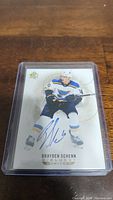 Photo of Brayden Schenn hockey card in protective plastic case showing autograph, player image, and card branding.