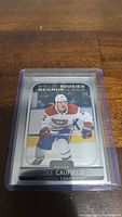 Front view of Cole Caufield rookie card in protective casing showing player in Montreal Canadiens uniform.