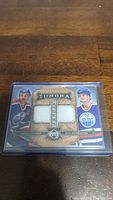 Front view of Upper Deck Artifacts Tundra tandem card showing images of Glenn Anderson and Mike Krushelnyski with two jersey swatches and serial number 60/125.