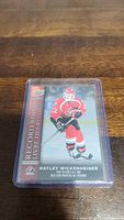 Photo of Hayley Wickenheiser Upper Deck Record Books hockey trading card in protective sleeve on wooden surface