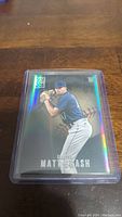 Single image of Matt Brash rookie baseball card inside protective plastic sleeve on wooden table surface.