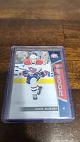 Nick Suzuki rookie hockey card showing player in Montreal Canadiens jersey skating on ice, labeled Rookie, in protective sleeve.