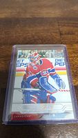 Photo of a single Patrick Roy hockey trading card encased in protective plastic holder, showing front side with image of Roy in Canadiens goalie gear on ice rink background.