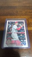 Baseball card of Shohei Ohtani in protective plastic case on wooden surface