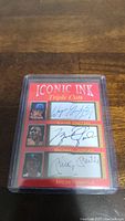 Red Iconic Ink Triple Cuts card with facsimile autographs of Wayne Gretzky, Michael Jordan, and Mickey Mantle protected in plastic case.