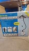 Box of the Conair Deluxe Fabric Steamer showing product branding, features, and commercial quality label.