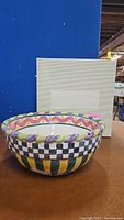 Front view of multicolored ceremonial bowl with original white presentation box behind.