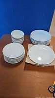 All plates and bowls stacked in three groups showing quantity and general condition