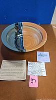 Photo of pottery bowl/platter with coupon and information cards.
