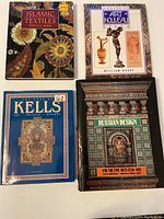 Top view showing the four hardcover books arranged with their covers visible: Islamic Textiles, A Guide to Art Nouveau, The Book of Kells, and Russian Design and the Fine Arts 1750-1917.