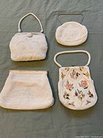 Four white seed bead evening purses laid out on a flat surface showing front views and details.