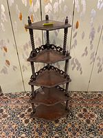 Front view of 5-tier corner whatnot shelf with turned spindle supports and dark wood finish, showing overall structure and condition.