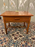 Front view of the teak night table, showing single drawer and tapered legs.