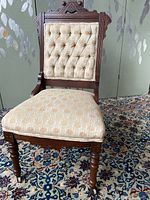 Full view of Victorian Eastlake chair showing solid wood frame, upholstered seat and back, caster wheels on front legs