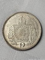 Obverse side of 1865 Brazilian silver coin showing crown, coat of arms, and inscription