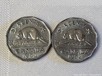 Photo showing two Canadian 5 cents coins from 1952 and 1953, both featuring a beaver on a rock, with visible wear from circulation.