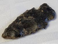 Close-up of flint tool front side, showing single sharp point and chipped edges