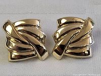 Close-up photo of one earring showing the abstract mid century design with polished folded silver ribbons.