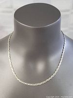Front view of the 18-inch sterling silver braided necklace displayed on a grey bust.