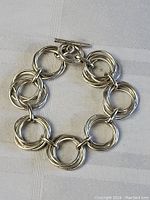 Top view of sterling silver hoop cluster bracelet laid flat showing the linked multiple hoops and toggle clasp closure.