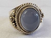 Front view of sterling silver ring with moonstone cabochon in detailed silver setting.