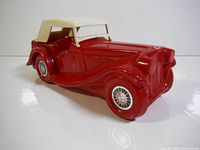 Front angled view of the red ceramic 1936 MG Avon bottle with white fabric roof.