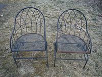 Front view of two metal rocking patio chairs on lawn