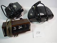 Photo showing 3 vintage alarm clocks and radios with power cords wrapped around each.